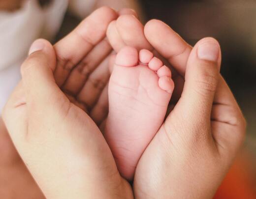 Babyfuß in Händen-klein Babyfuß in Elternhänden