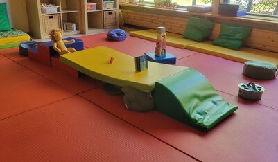 Raum mit roten und gelben Matten und Spielzeug